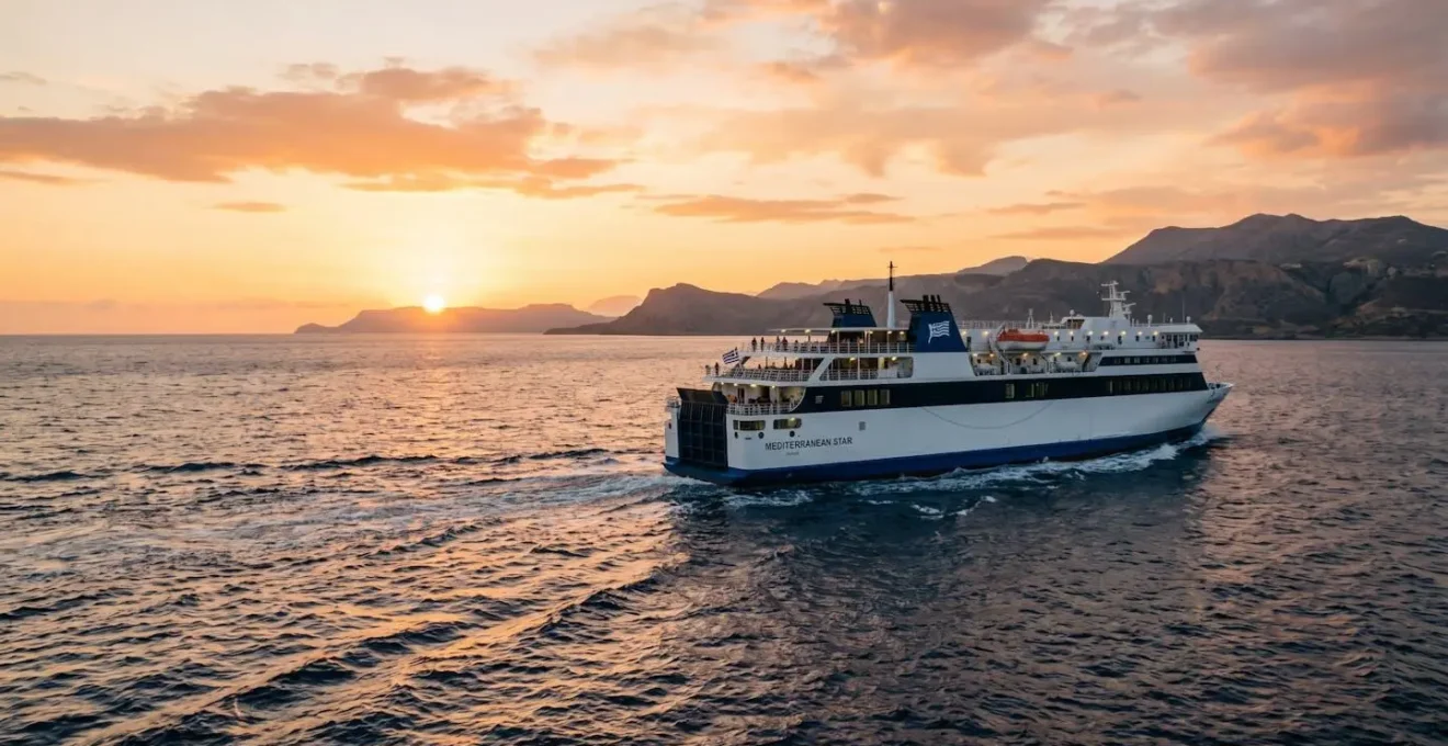 Un ferry moderne naviguant en mer Méditerranée au coucher du soleil, coque blanche et bleue illuminée par une lumière dorée naturelle